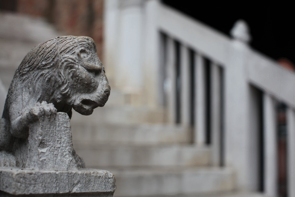 A statue of a lion on an entryway railing