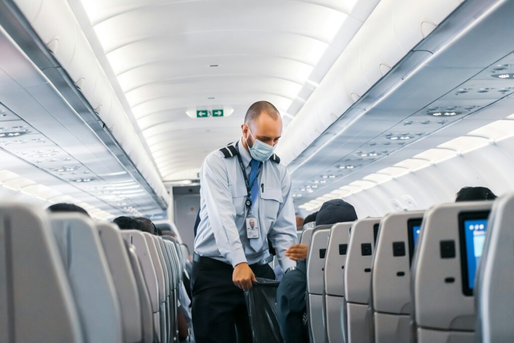 man in blue dress shirt standing in airplane
