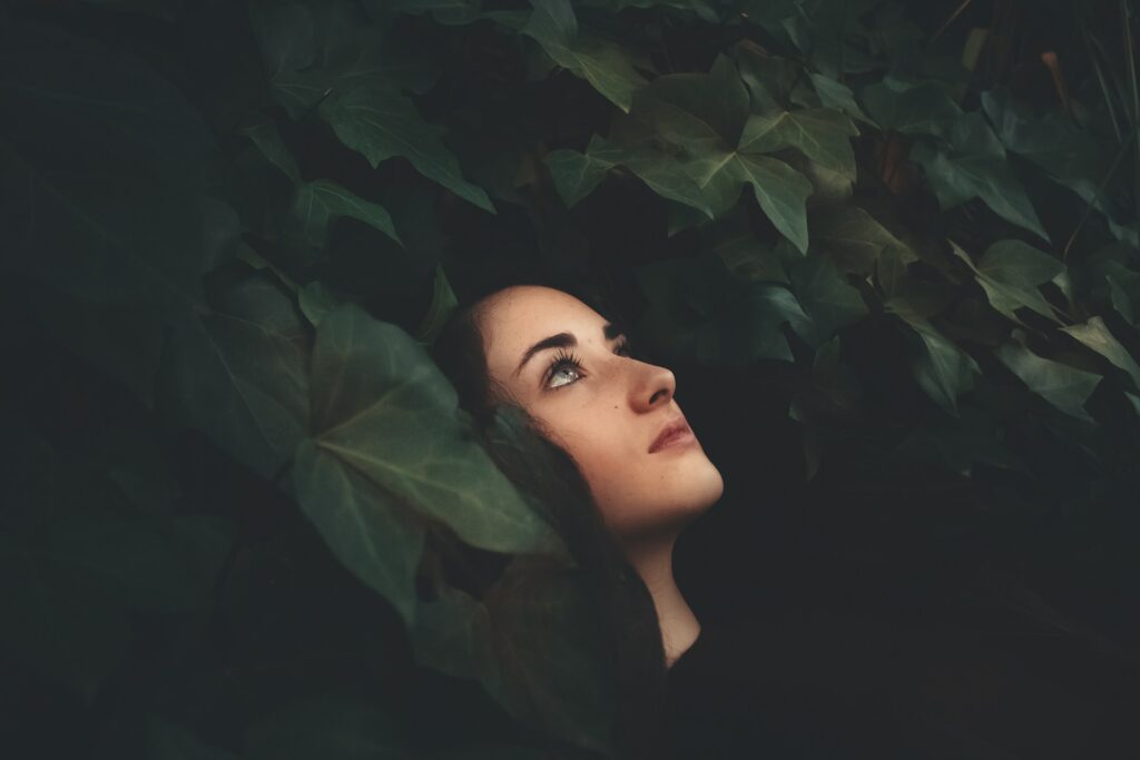 woman in black top surrounded by leaves