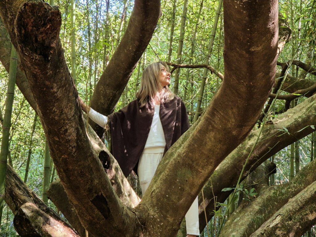 Woman standing in a large tree with bamboo background