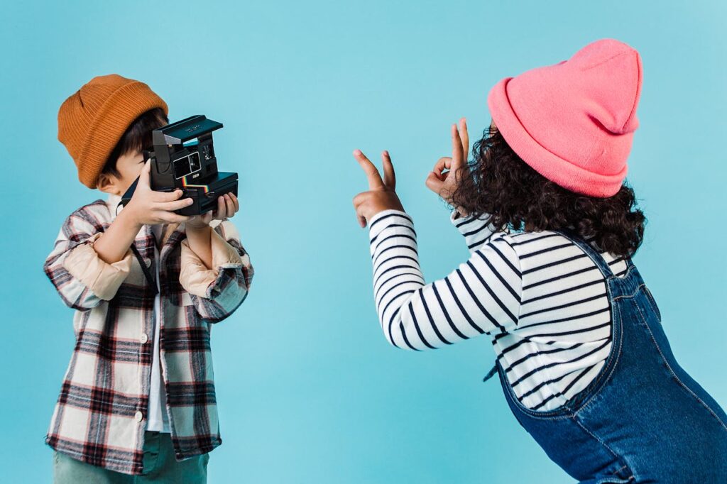 Positive diverse children taking photo on instant photo camera
