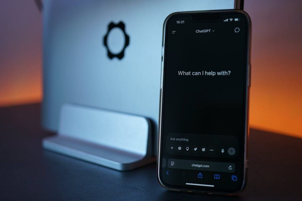Smartphone Displaying Chat Interface with Laptop

