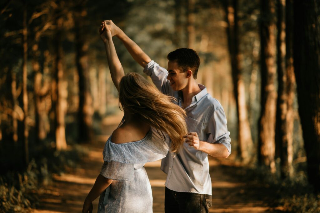 man and woman dancing at center of trees
