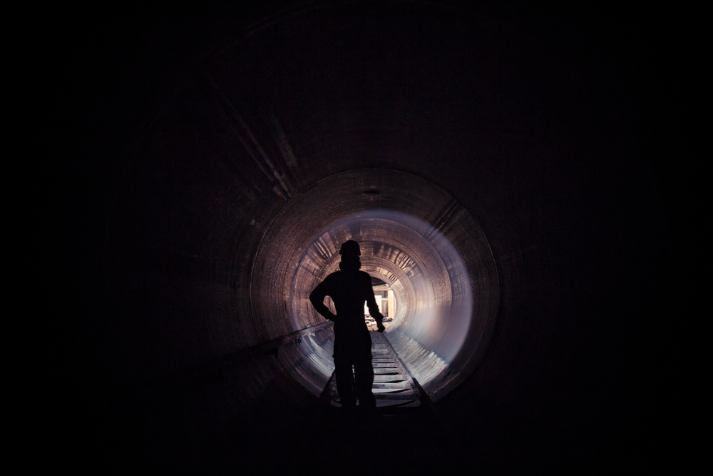 Working male inspection weld underground of equipment tunnel By using the flashlight.