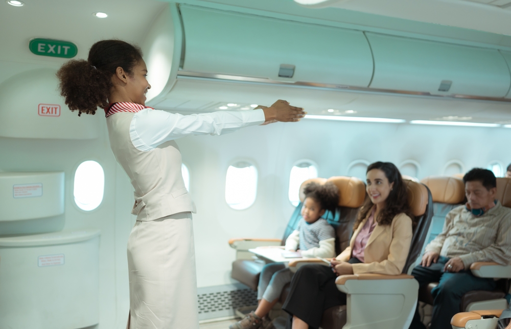 Flight attendants show how to use safety devices and recommend emergency exits.