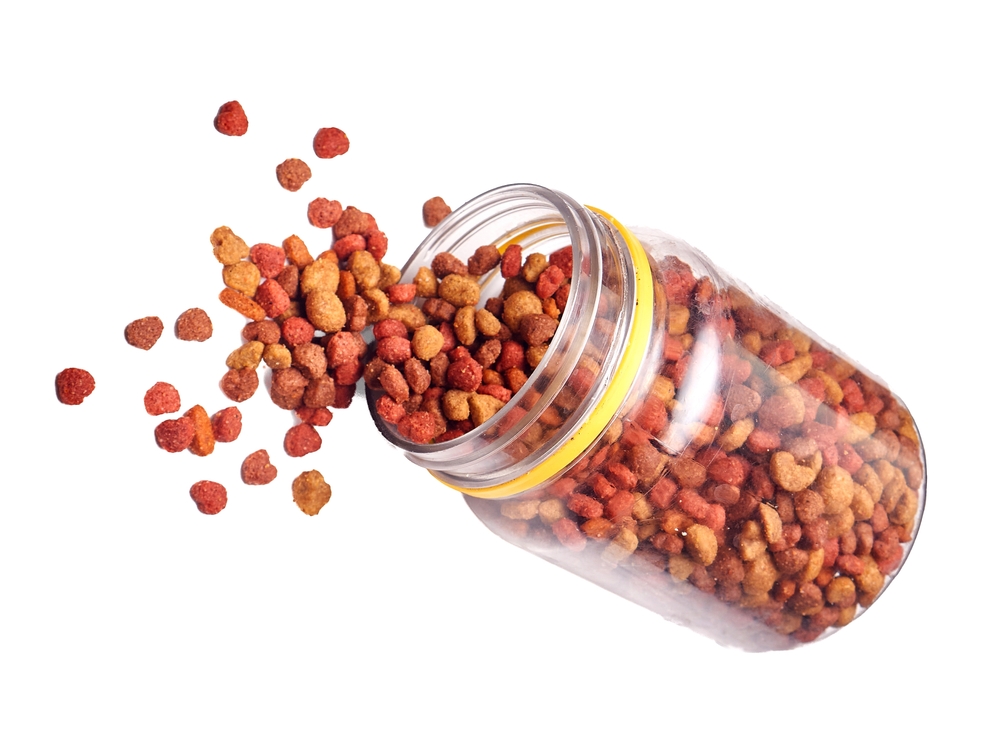 Jar Spilling Dry Pet Food Isolated on White Background