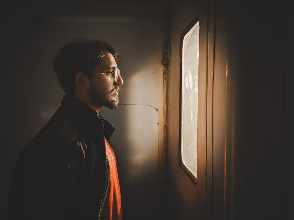 Pensive Man Gazing Out Window in Warm Light