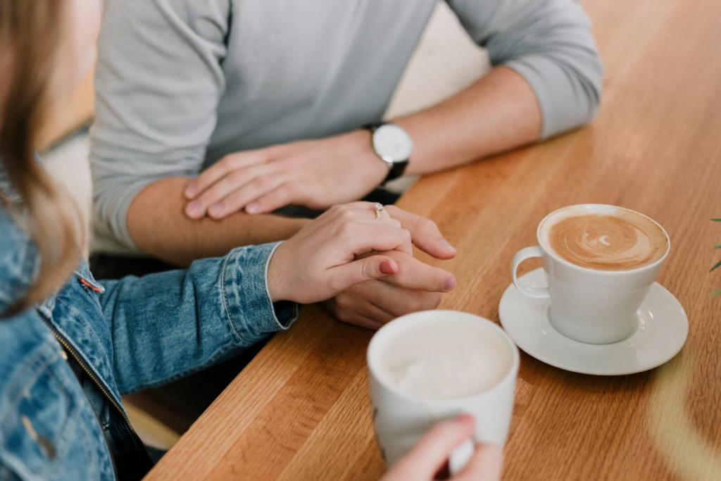Couple holding hands at a cafe.
