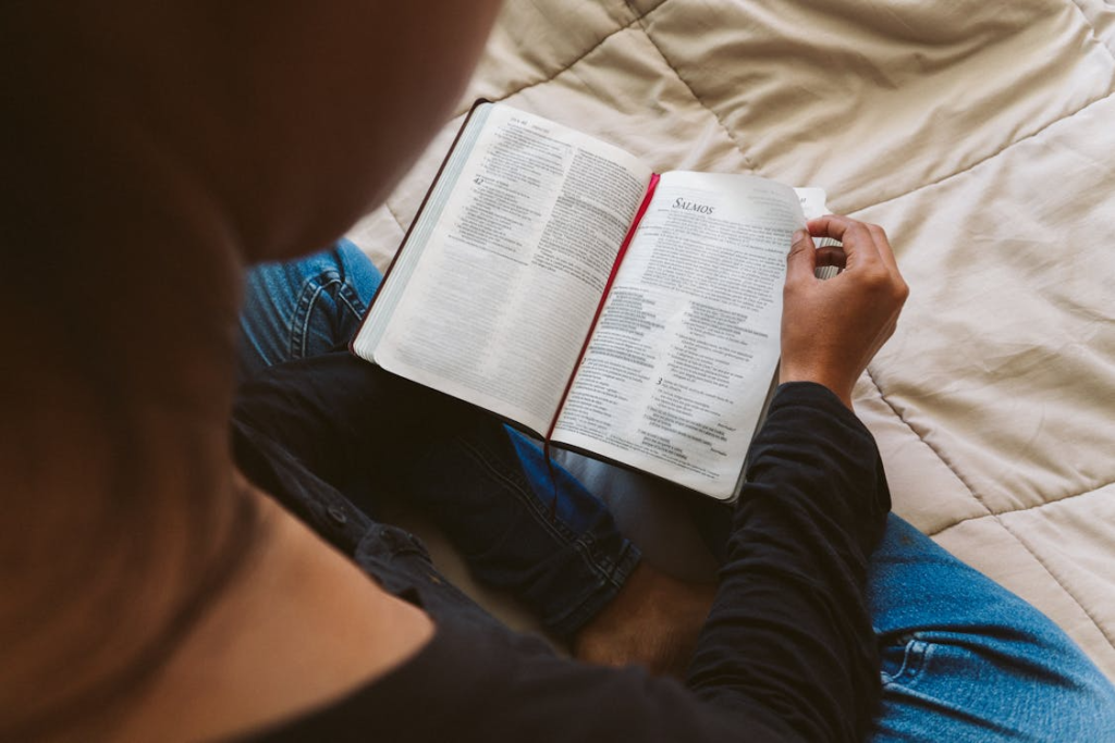 A person reading a book in a bed,