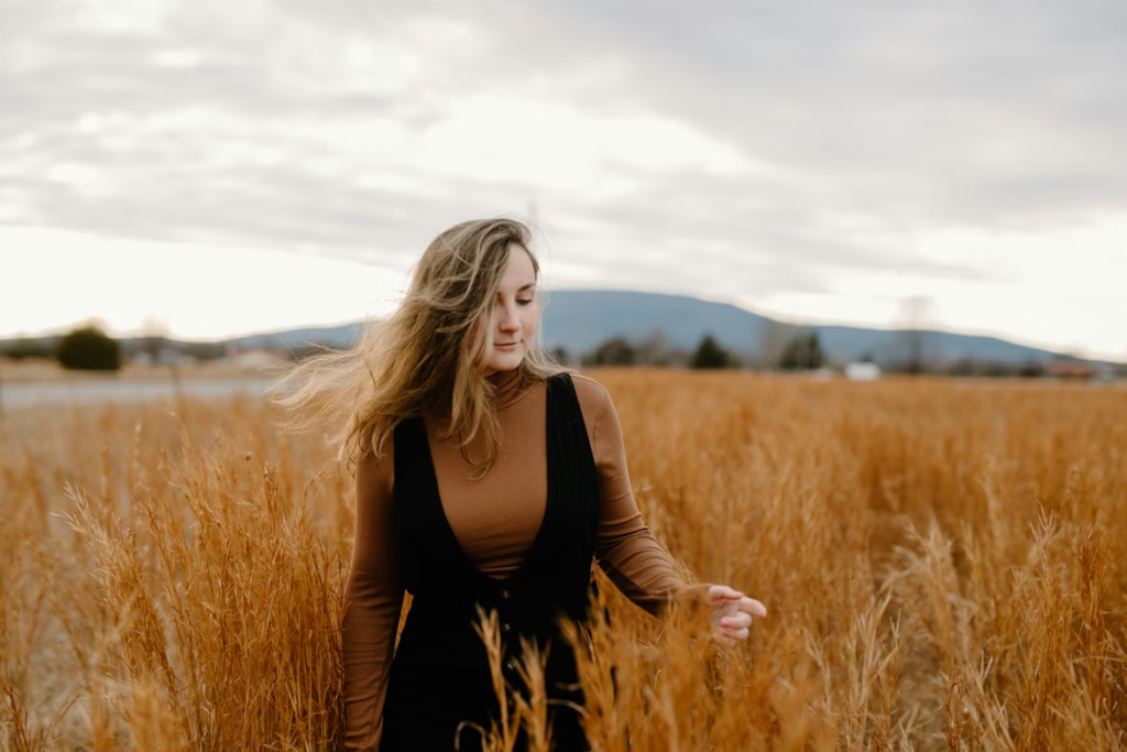 woman-in-black-long-sleeve-shirt-standing-on-brown-grass-field-during-daytime
