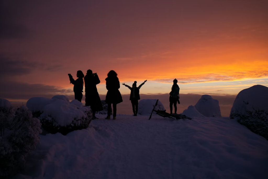 silhouette-of-people-on-snow-covered-ground-during-sunset