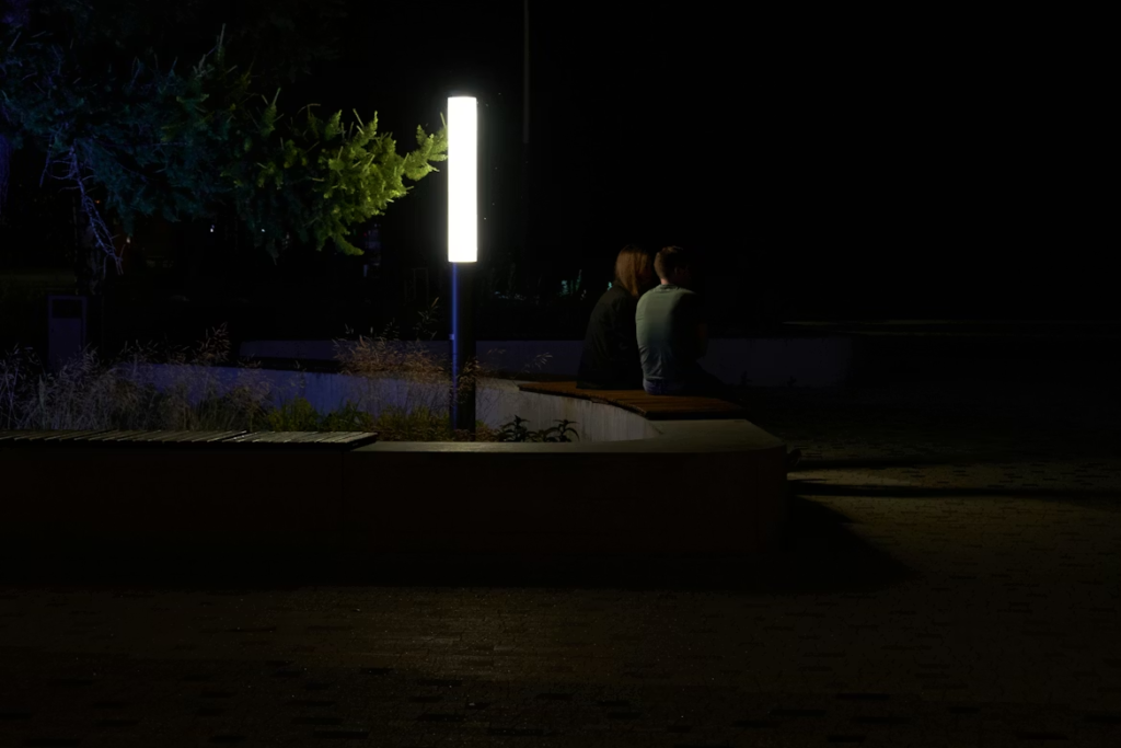 a-couple-sitting-on-a-bench-at-night