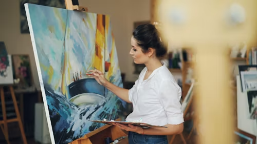 a-woman-paints-a-blue-and-white-artwork