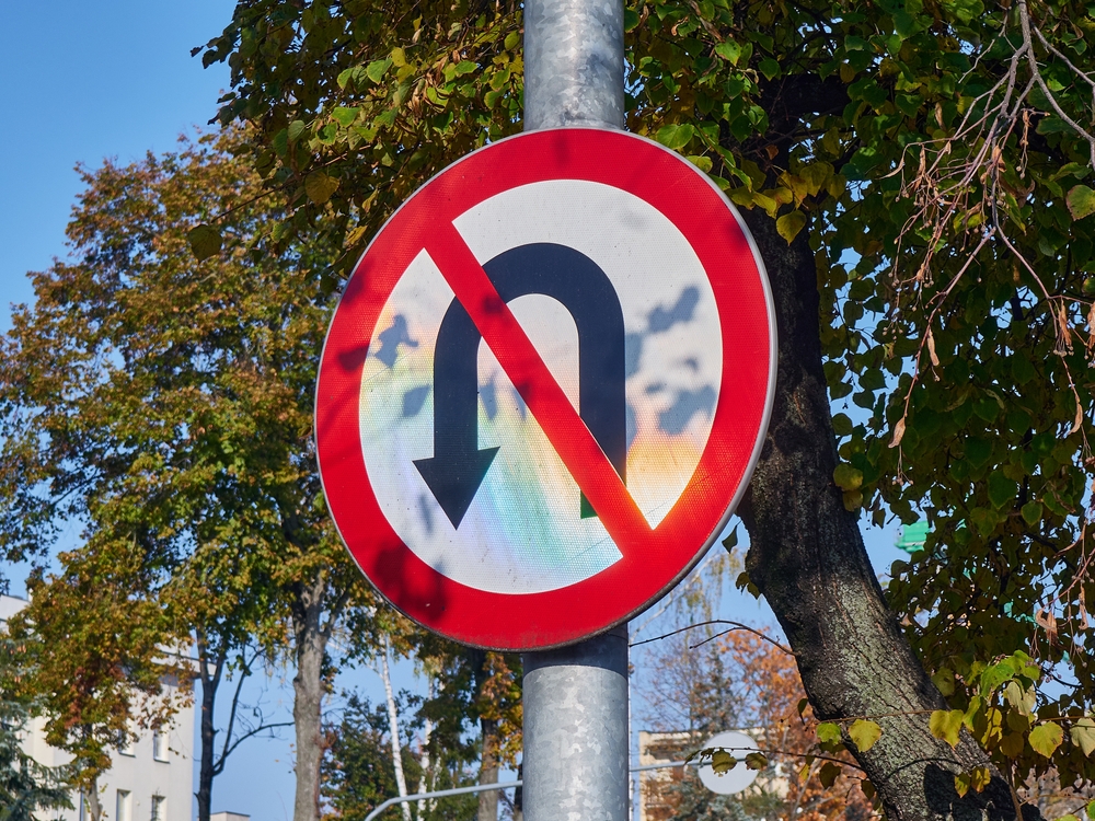 No U-Turn Road Sign Against Autumnal Trees