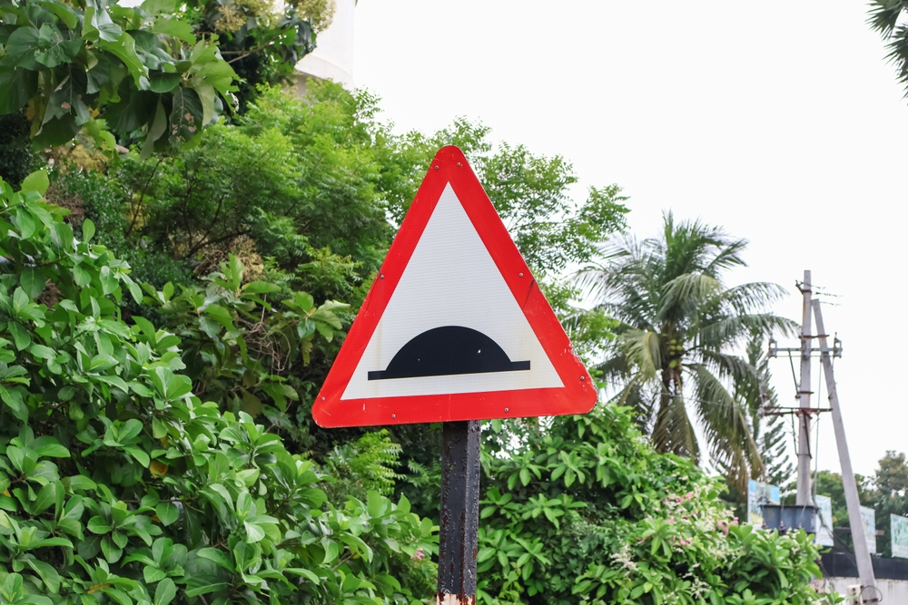 Speed hump or Sleeping Policeman sign. A traffic road safety sign.