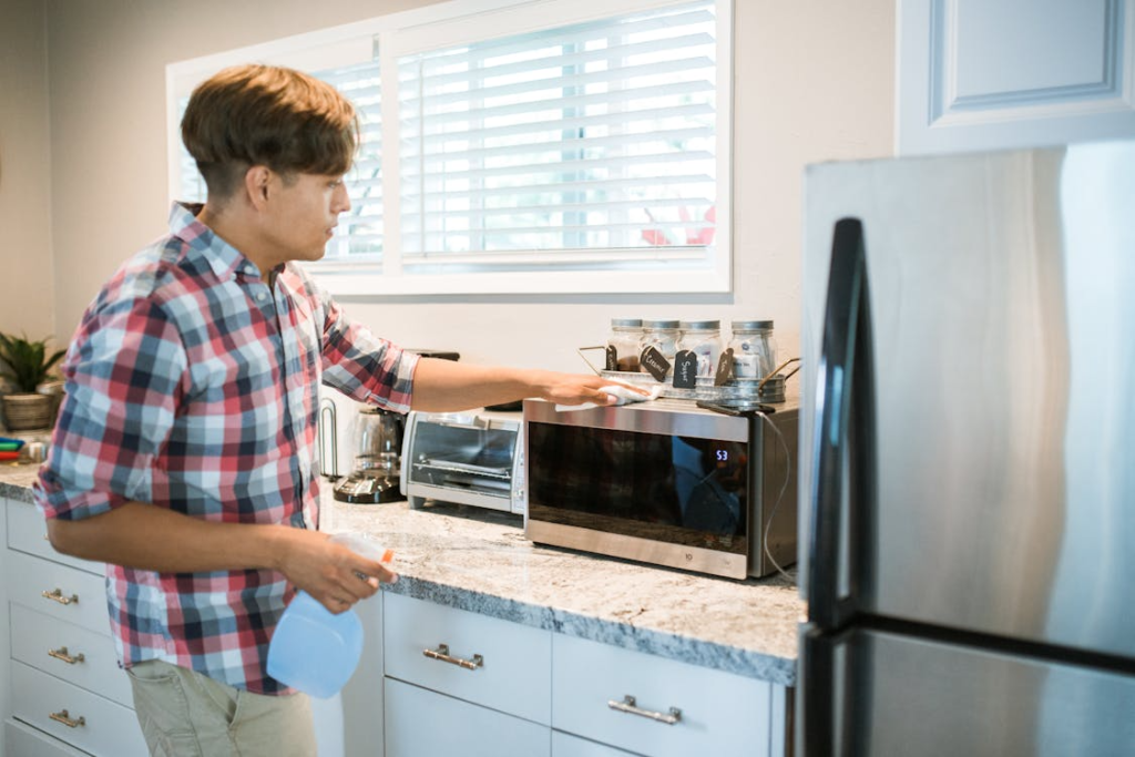 man cleaning microwave