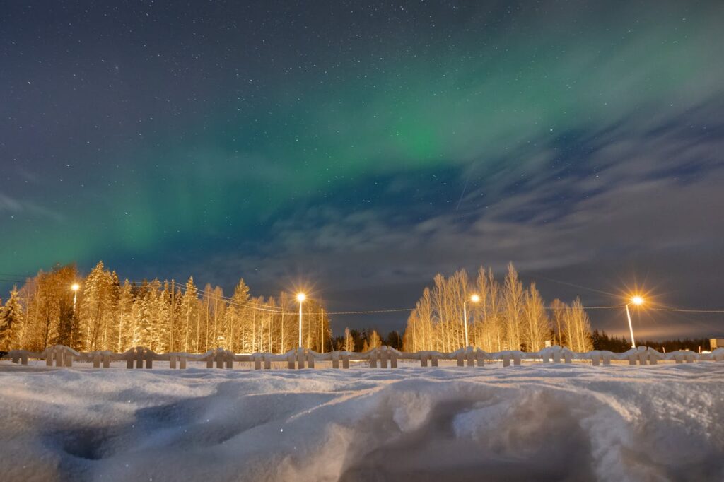 Aurora Borealis over Snowy Lapland Landscape
