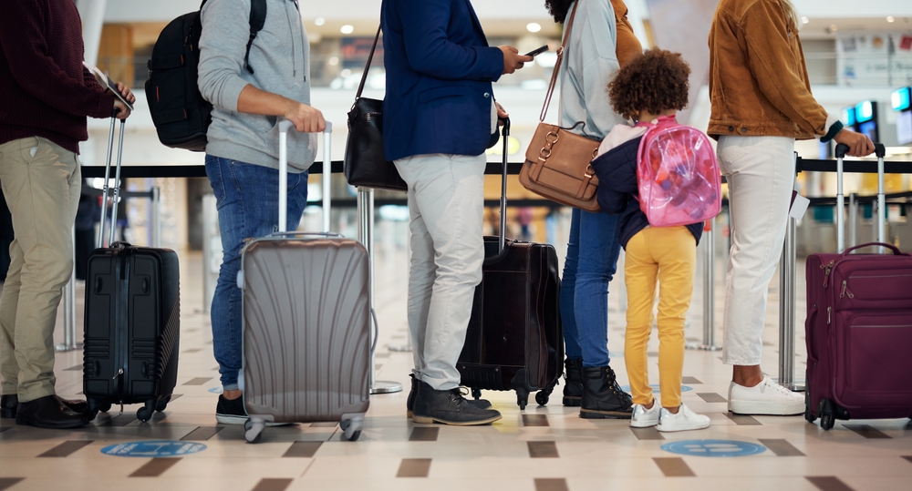 Airport queue, travel and people legs for international vacation, holiday or immigration with suitcase and kid. Line or group of women, men and child with luggage waiting for global flight schedule

