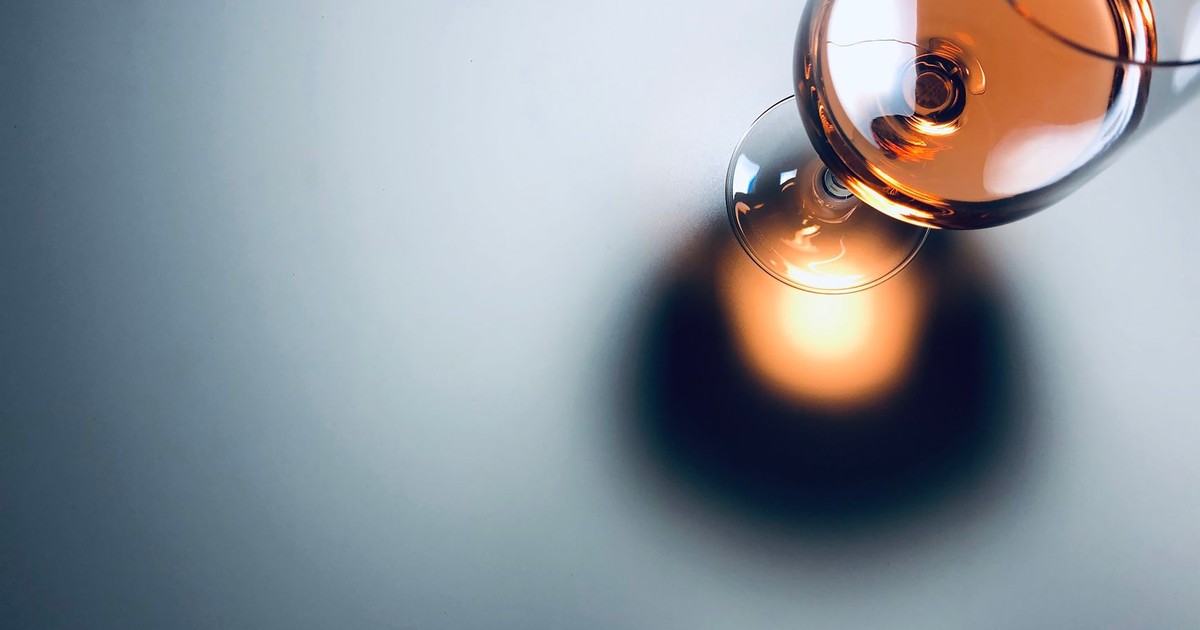 Elegant close-up of a half-full wine glass casting a shadow, perfect for beverage and lifestyle themes.