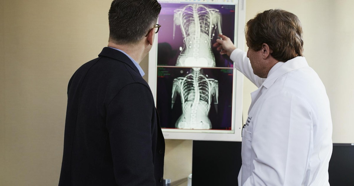 A doctor explains X-ray results to a patient in a clinical setting, highlighting healthcare communication.