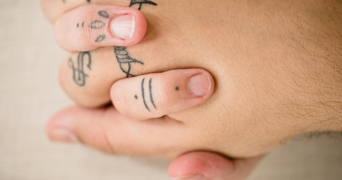 Intimate close-up of tattooed hands, symbolizing love and connection.