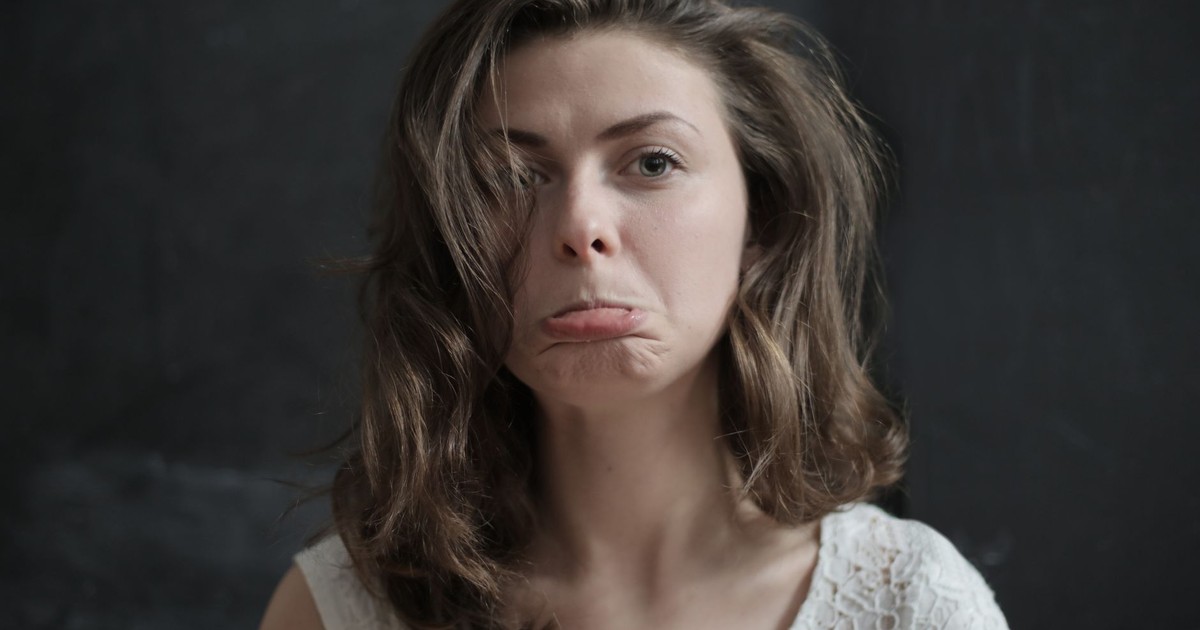Portrait of a woman displaying a sad expression in a studio setting.