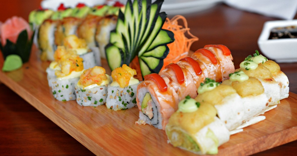 Colorful sushi platter featuring various rolls with decorative garnishes, showcasing culinary art.