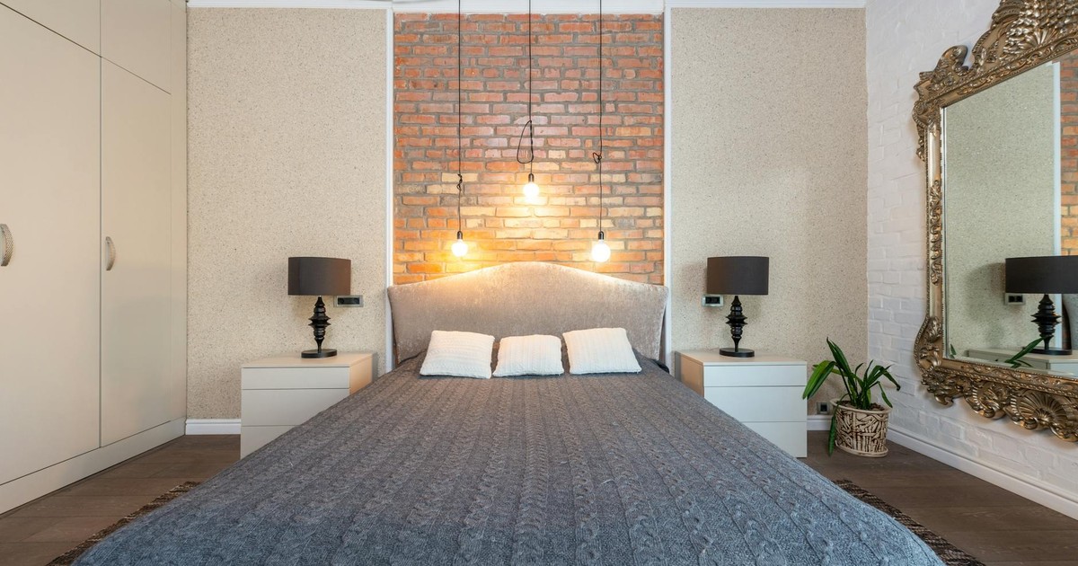 Contemporary bedroom featuring a stylish brick accent wall and elegant decor.