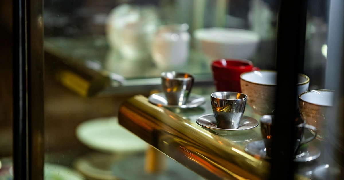 Close-up of an elegant coffee cup display in a Faridpur café, showcasing metal and ceramic cups.