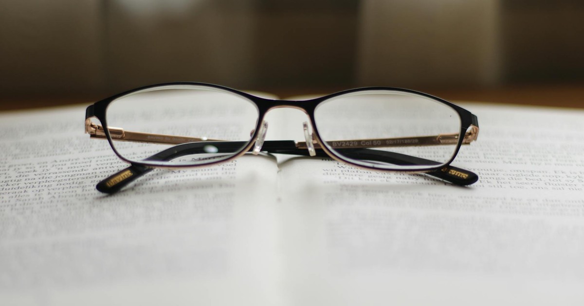 Close-up of reading glasses on an open book, symbolizing study and learning.