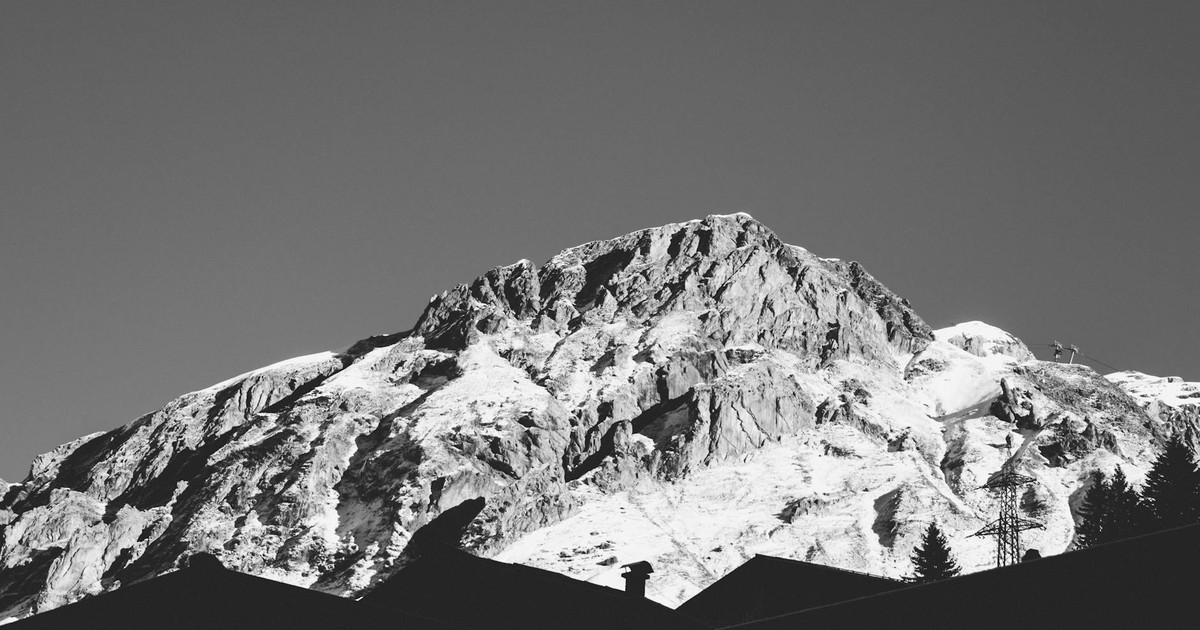 Black and white panorama of snow-covered Alpine peaks in Austria, captured in winter.