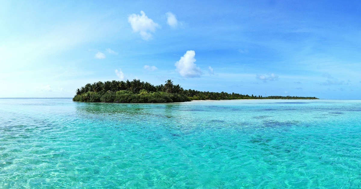 A beautiful tropical island surrounded by clear blue waters and a vivid sky, ideal for travel and vacation.