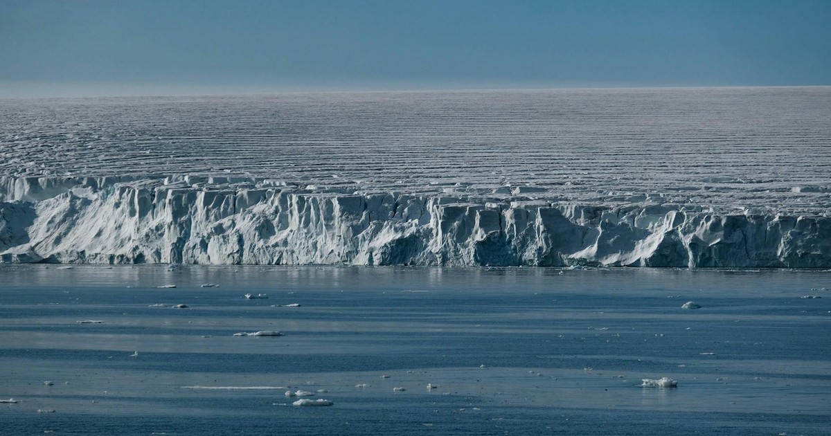 Stunning view of a vast ice shelf merging with the cold ocean waters, capturing nature's raw beauty.