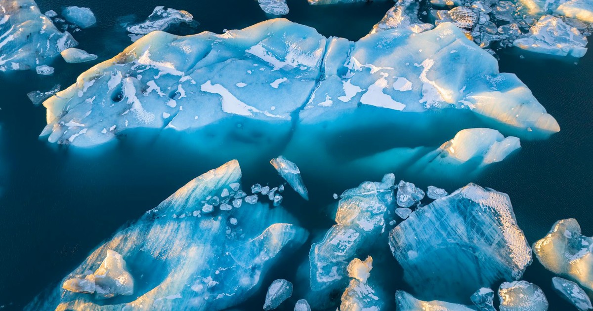 Stunning aerial view of large icebergs floating in deep blue waters.