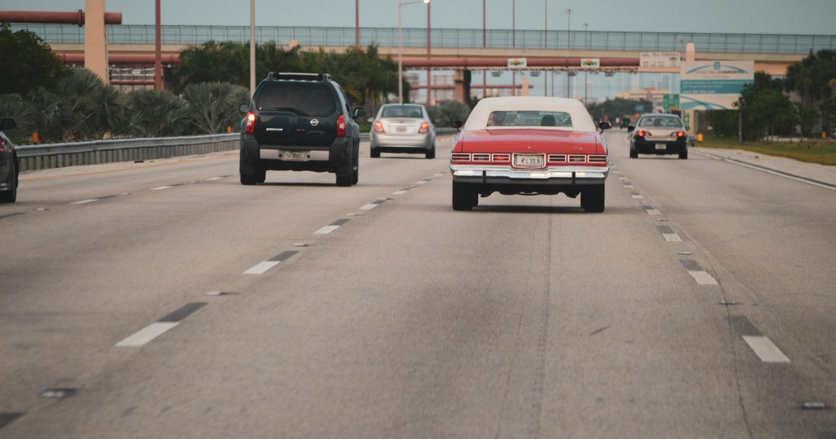 Highway traffic scene with classic car in Miami, Florida, showcasing urban travel atmosphere.