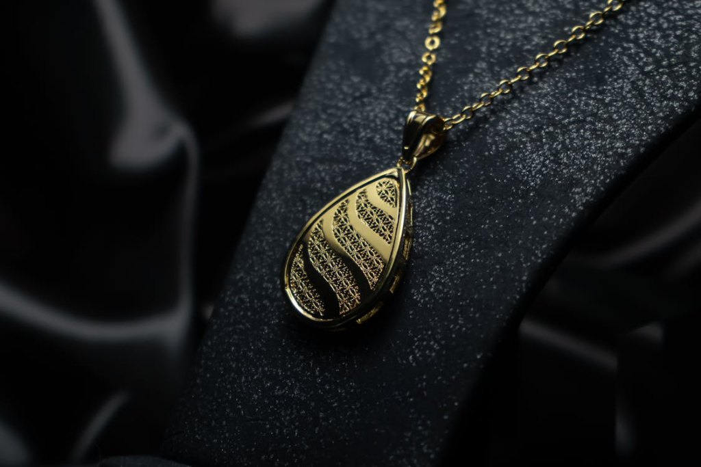 Close-up of an intricately designed gold necklace pendant exuding luxury and elegance.