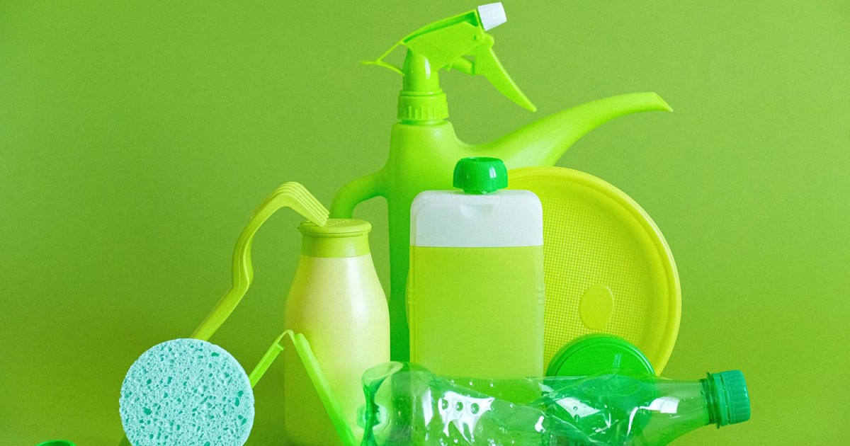 Monochrome green bottles and containers for liquids or gel with plastic bottle and lids on green background