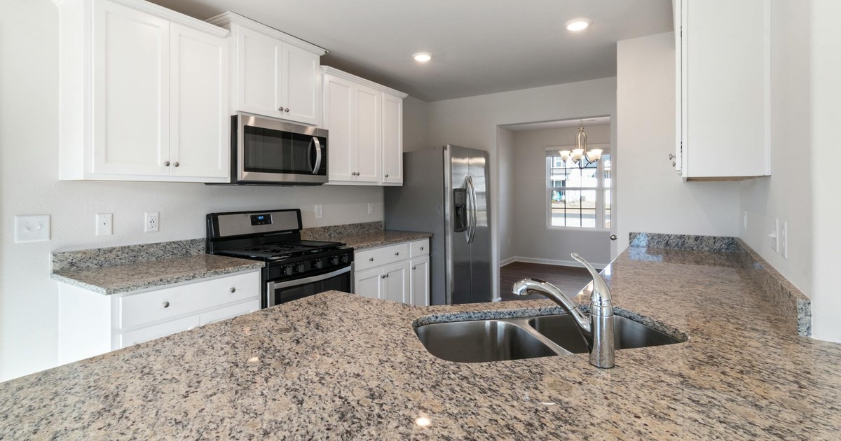 Sleek kitchen interior featuring granite countertops and stainless steel appliances.