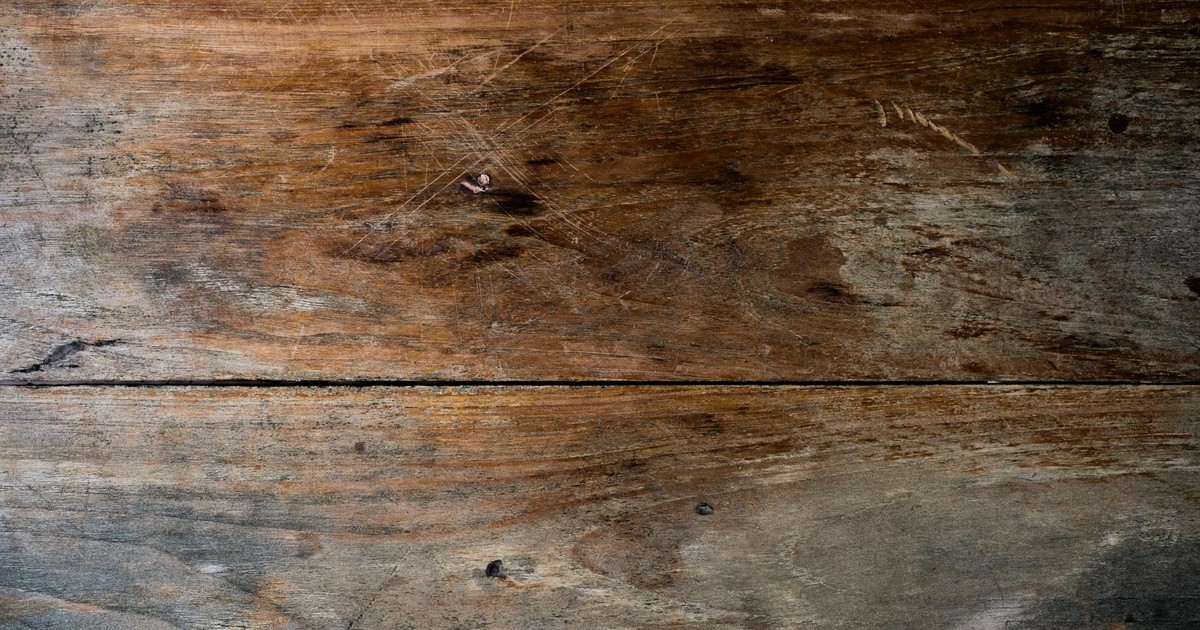 Close-up view of a rustic wooden plank with a textured, weathered finish ideal for backgrounds.