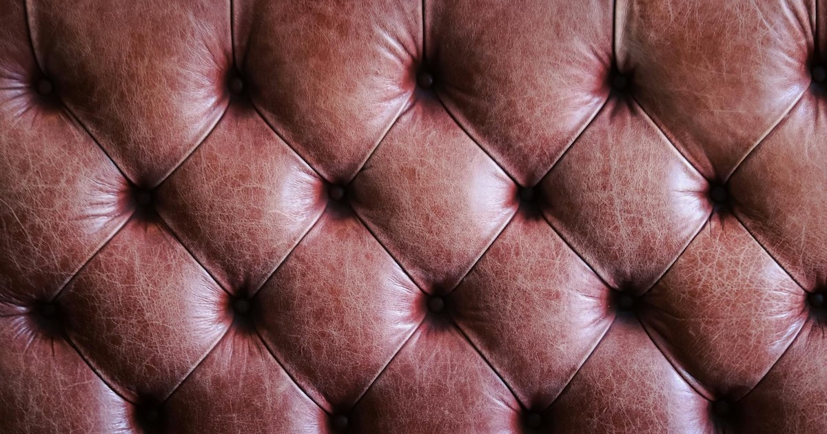 Close-up of tufted brown leather upholstery showcasing a vintage texture.