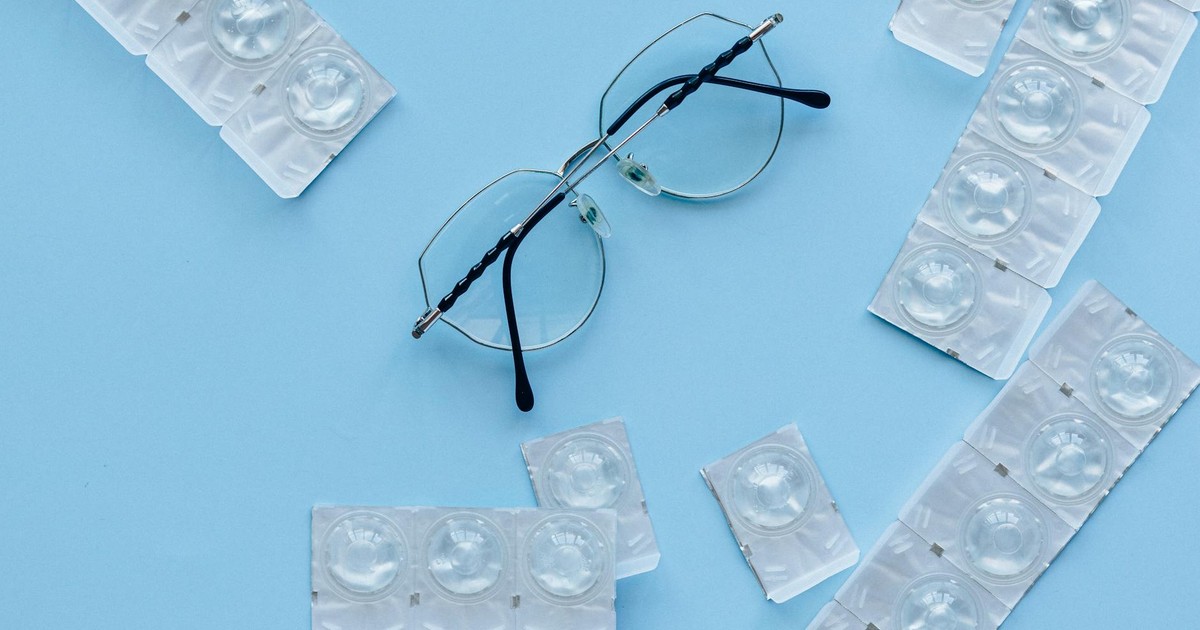 Eyeglasses and contact lenses on a blue background. Concept of eye care and vision correction.