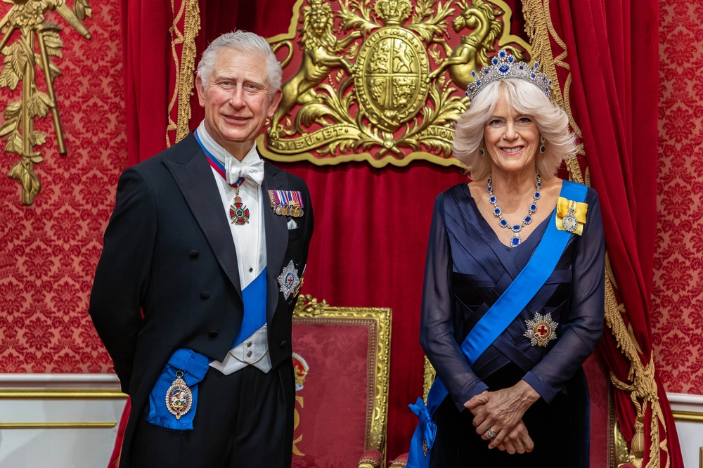 LONDON, UK - JANUARY 28, 2025: Detailed close up of King Charles III and Queen Camilla wax figures at Madame Tussauds London, set against an ornate royal backdrop