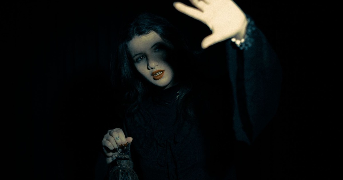 An enigmatic woman surrounded by darkness, holding a lantern, creating a mysterious atmosphere.