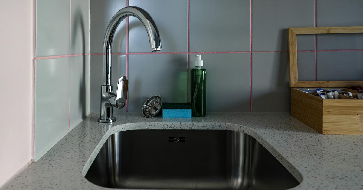 Stylish kitchen sink setup featuring chrome faucet, countertop, and accessories.