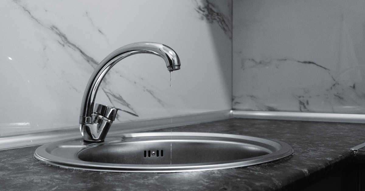 A clean and modern kitchen sink with a chrome faucet, highlighting minimalist design and water conservation.