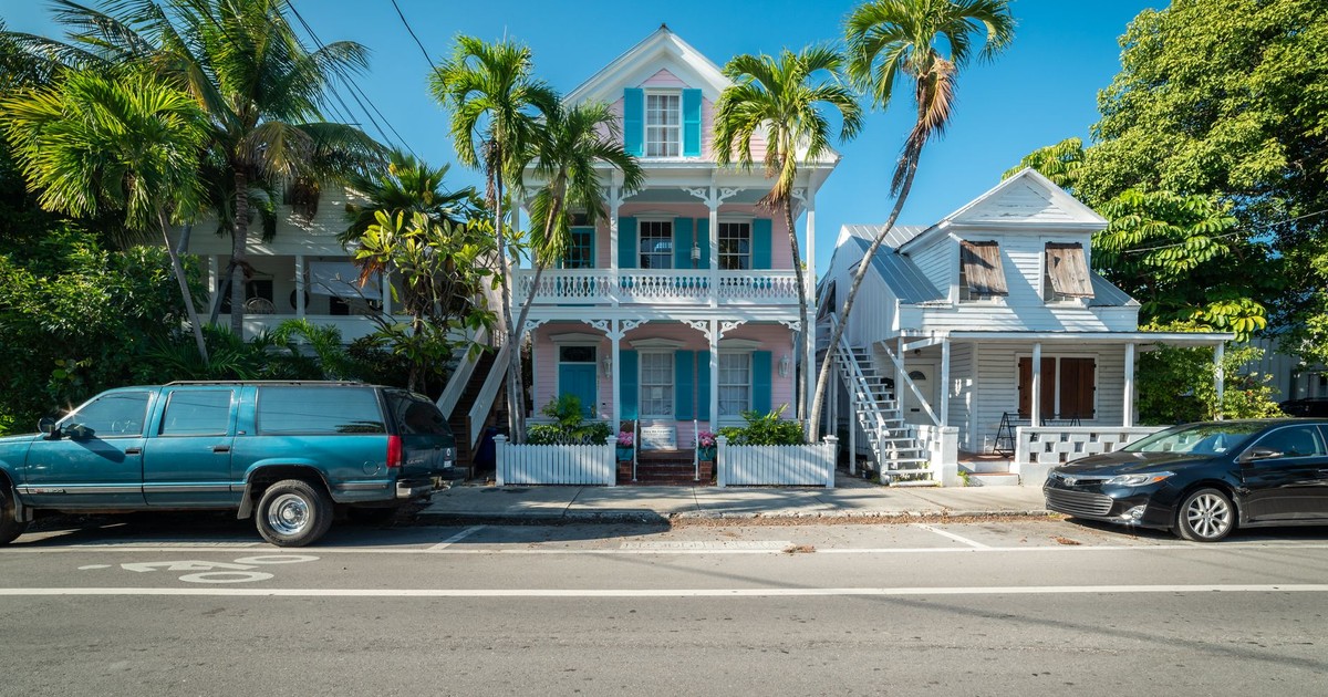 Colorful historic houses with palm trees along a sunny street in Key West, Florida.