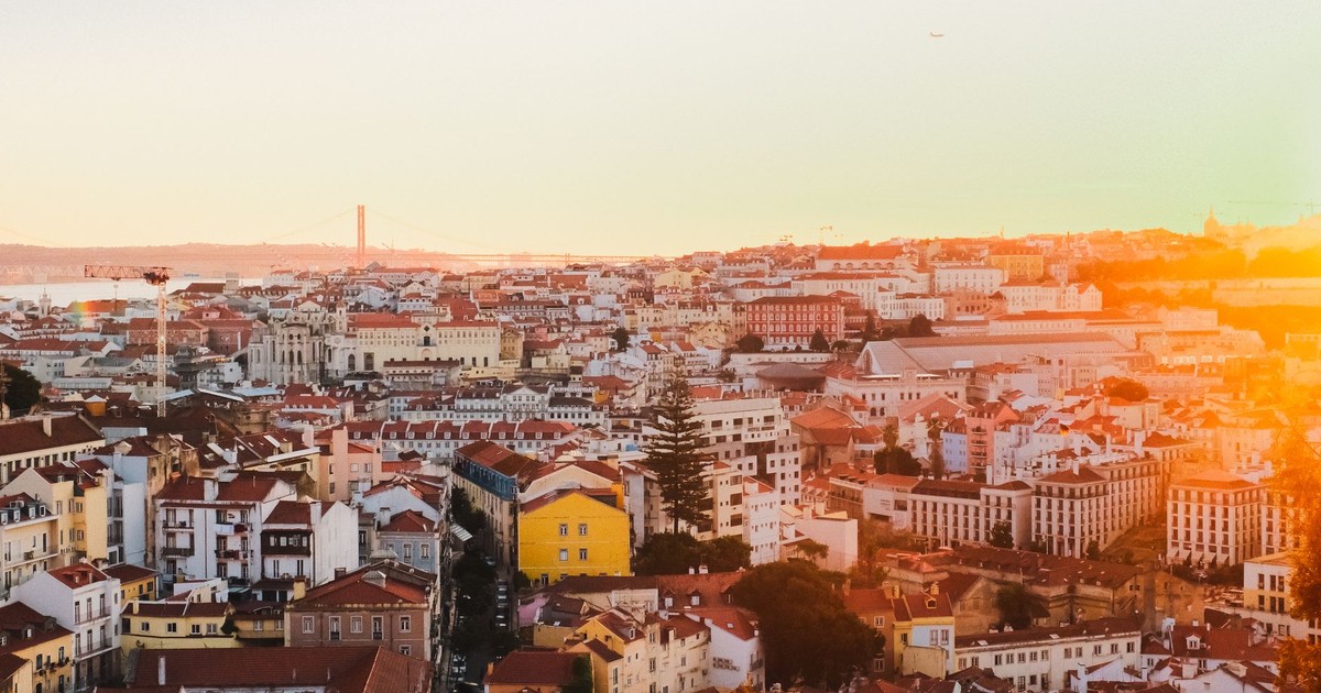 A breathtaking view of Lisbon's historic cityscape with vibrant rooftops at sunset.