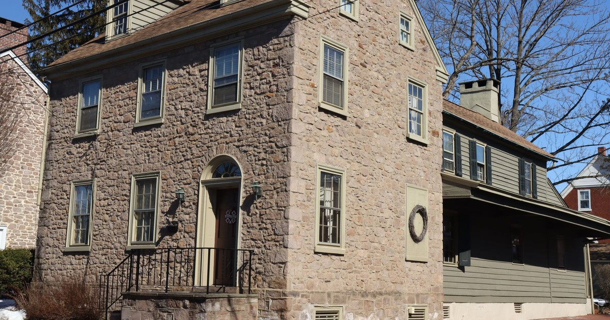Charming stone house with colonial architecture in Newtown, PA on a sunny day.