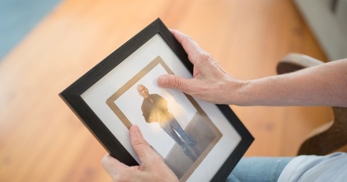 A pair of hands gently holding a picture frame, invoking memories and emotions.