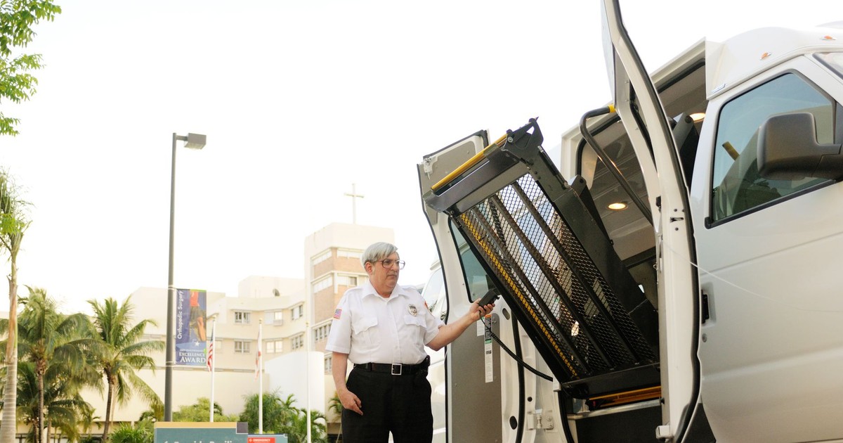 Security guard using a truck lift outside Bayside Pavilion for valet parking service.